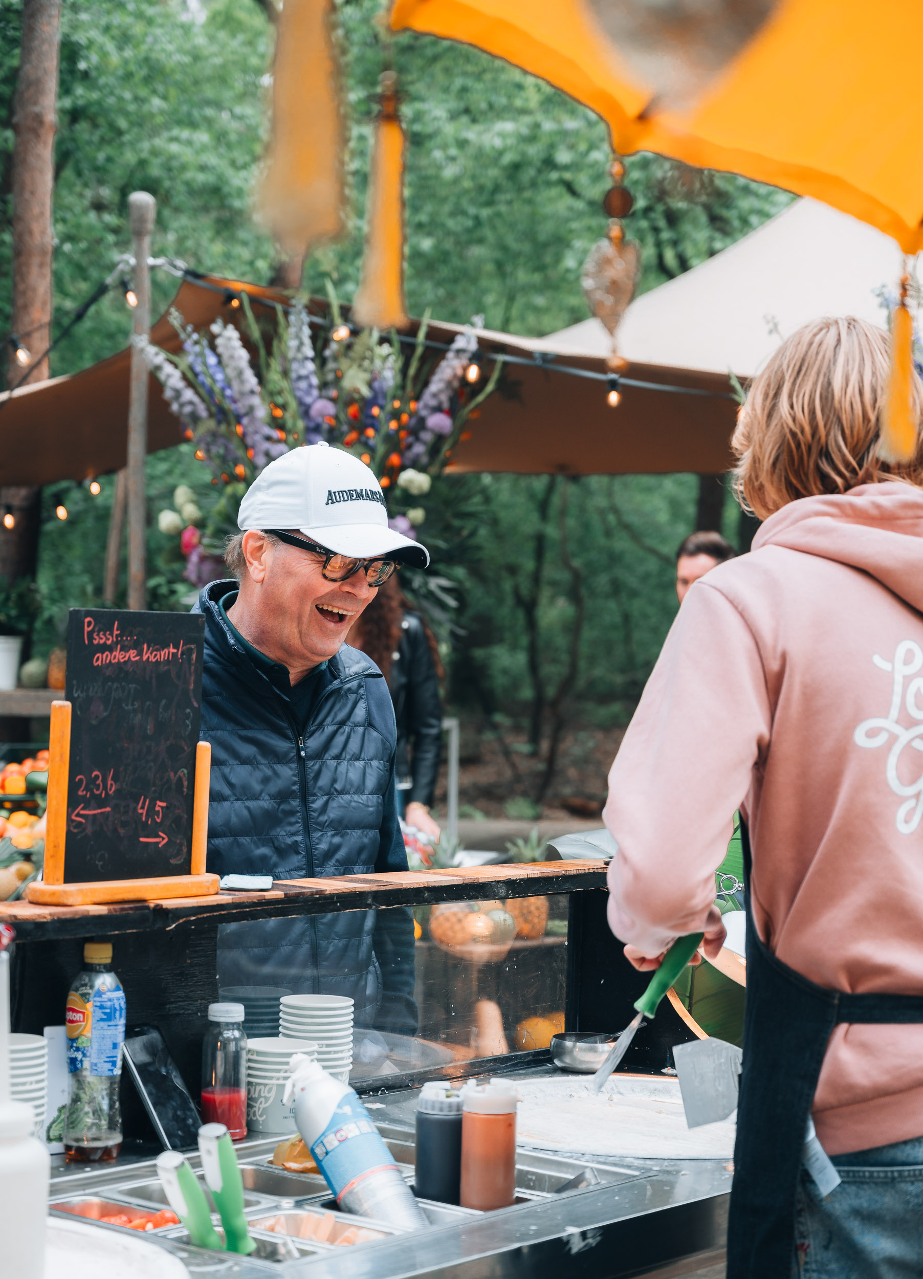 Medewerker bereidt eten bij een foodstand tijdens een horeca-evenement
